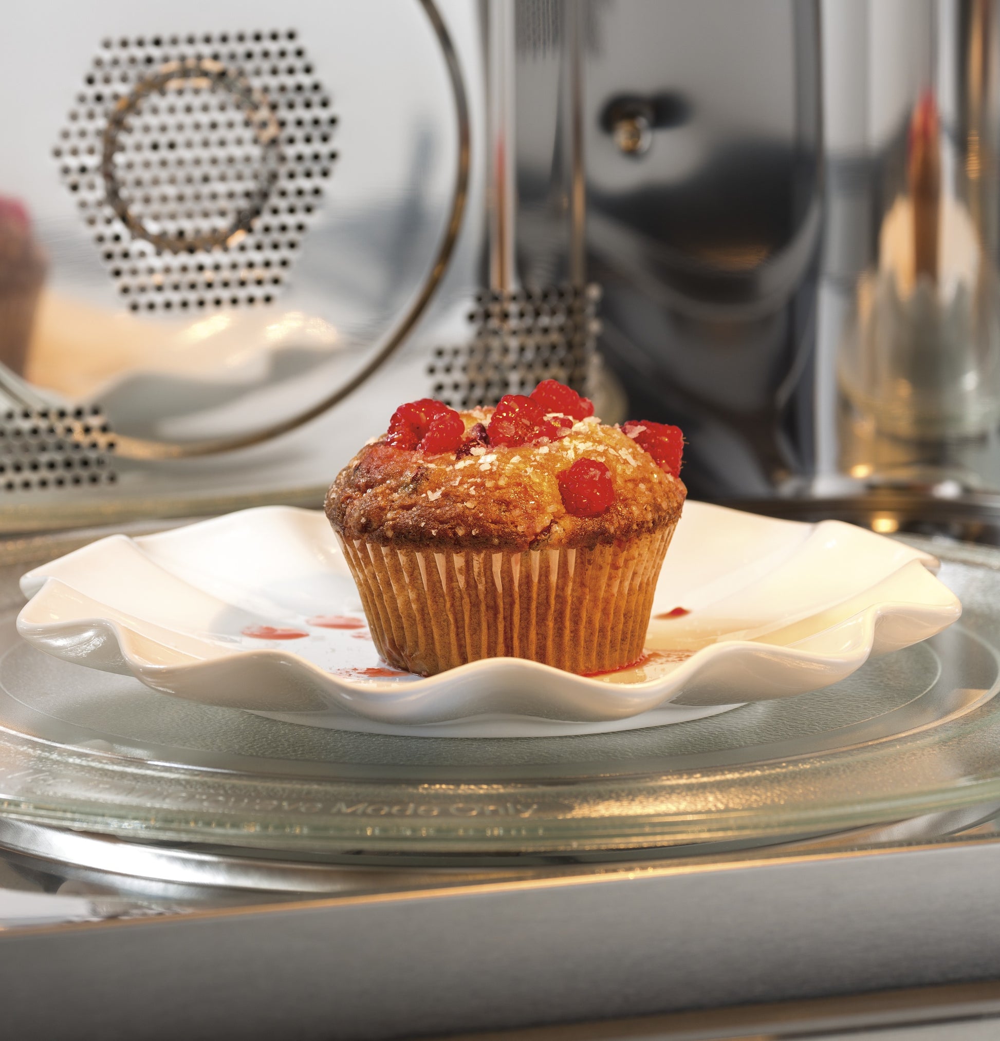 Cherry muffin on a white plate inside a stainless steel built-in microwave from the Built-in Microwaves collection