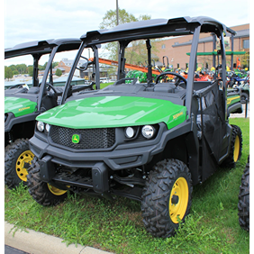 Green full-size crossover utility vehicle with rugged tires and protective roof for outdoor and home improvement tasks