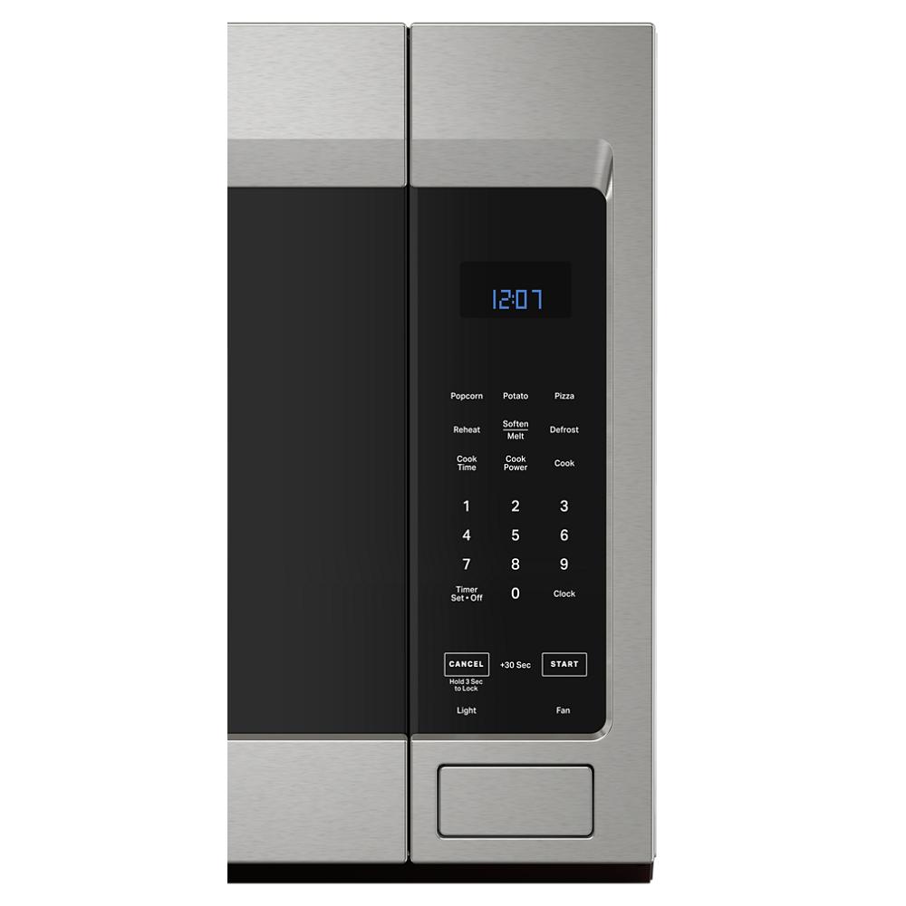 Close-up of stainless steel microwave control panel with digital clock and preset cooking functions in kitchen appliance setting