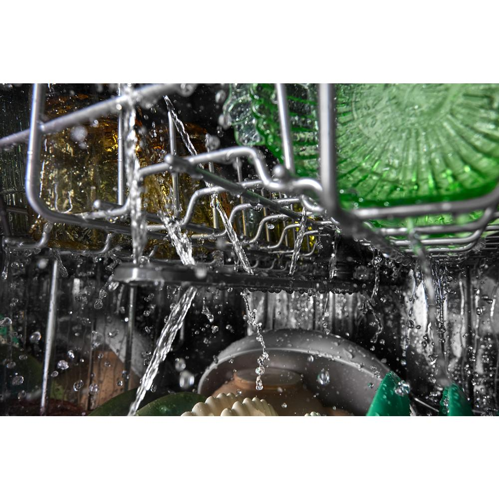Water spraying inside dishwasher rack loaded with glassware and dishes during cleaning cycle in home appliance setting