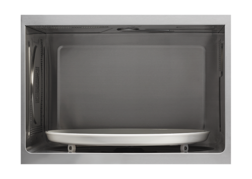 Interior view of stainless steel microwave oven cavity with white carousel tray for kitchen use