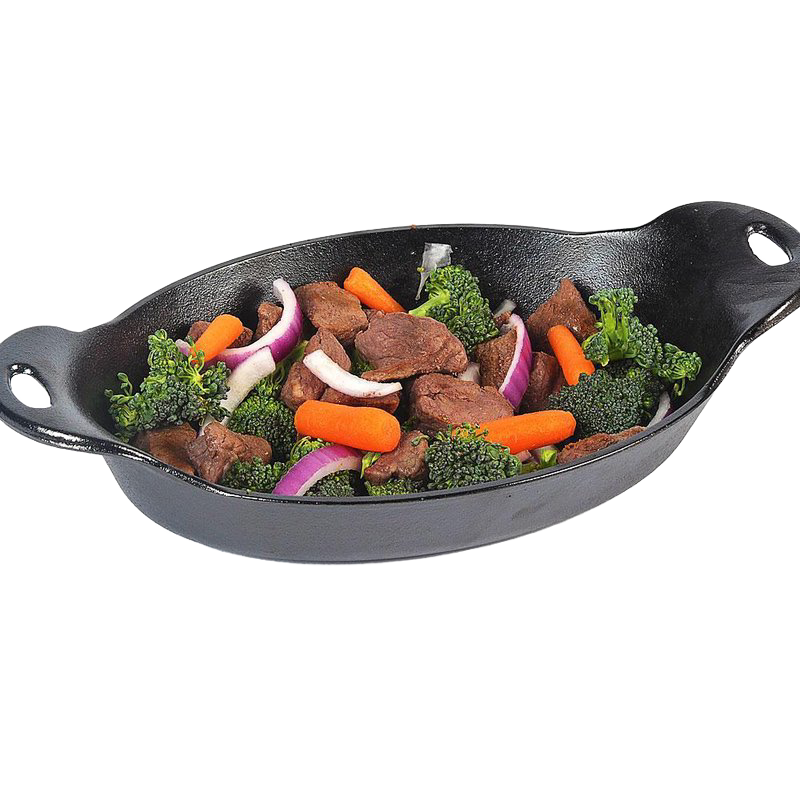 Oval cast iron serving dish with cooked beef, broccoli, baby carrots, and red onion for tableware and kitchenware use