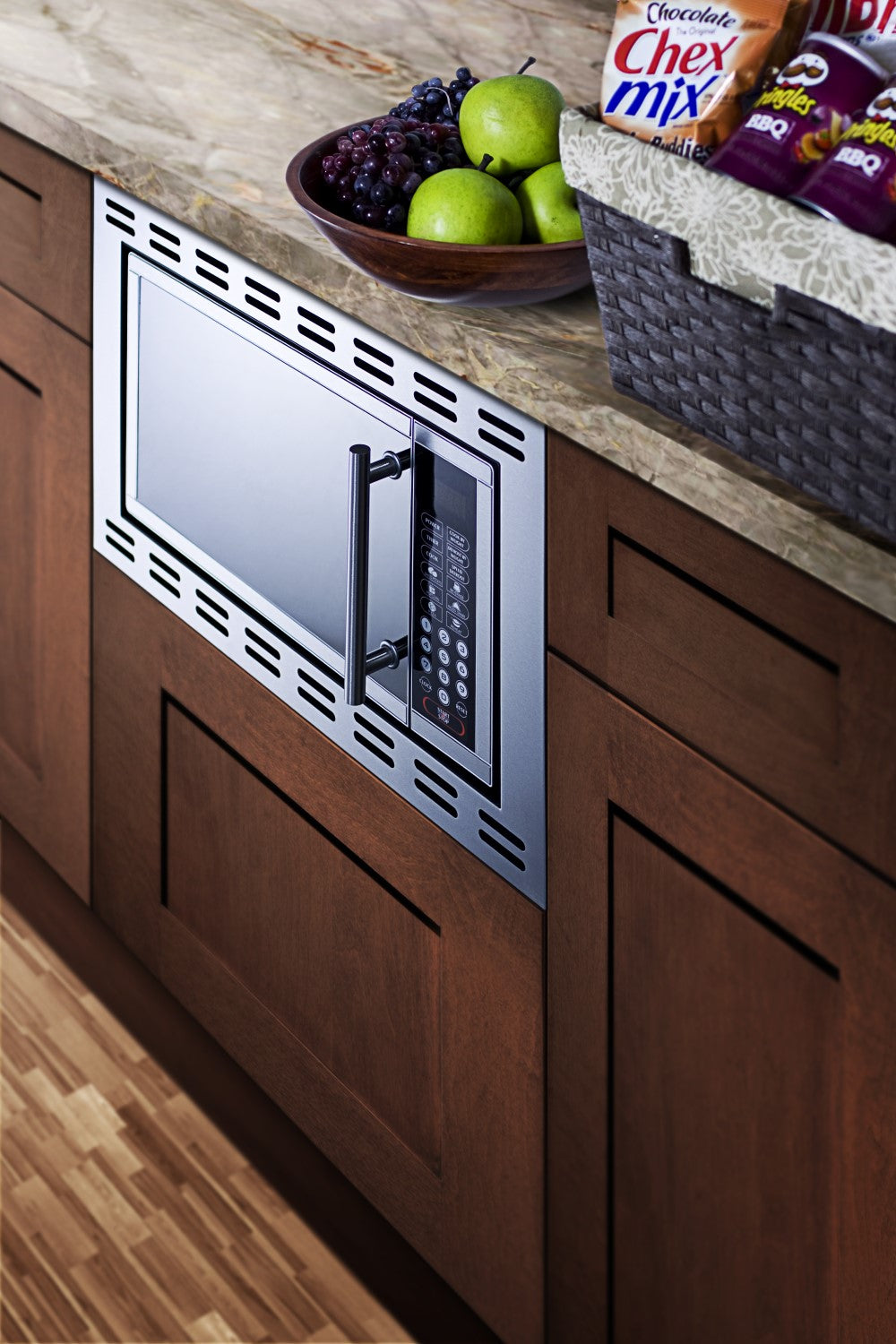 Stainless steel built-in microwave with digital keypad integrated into wood cabinetry and granite countertop in kitchen setting