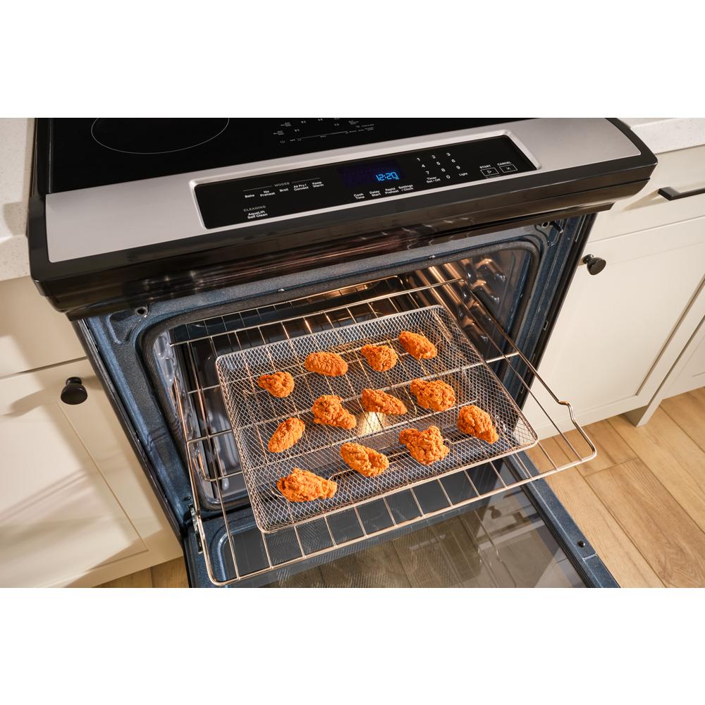 Open oven of 30-inch induction range with no preheat air fry cooking breaded chicken pieces on wire rack tray in kitchen setting