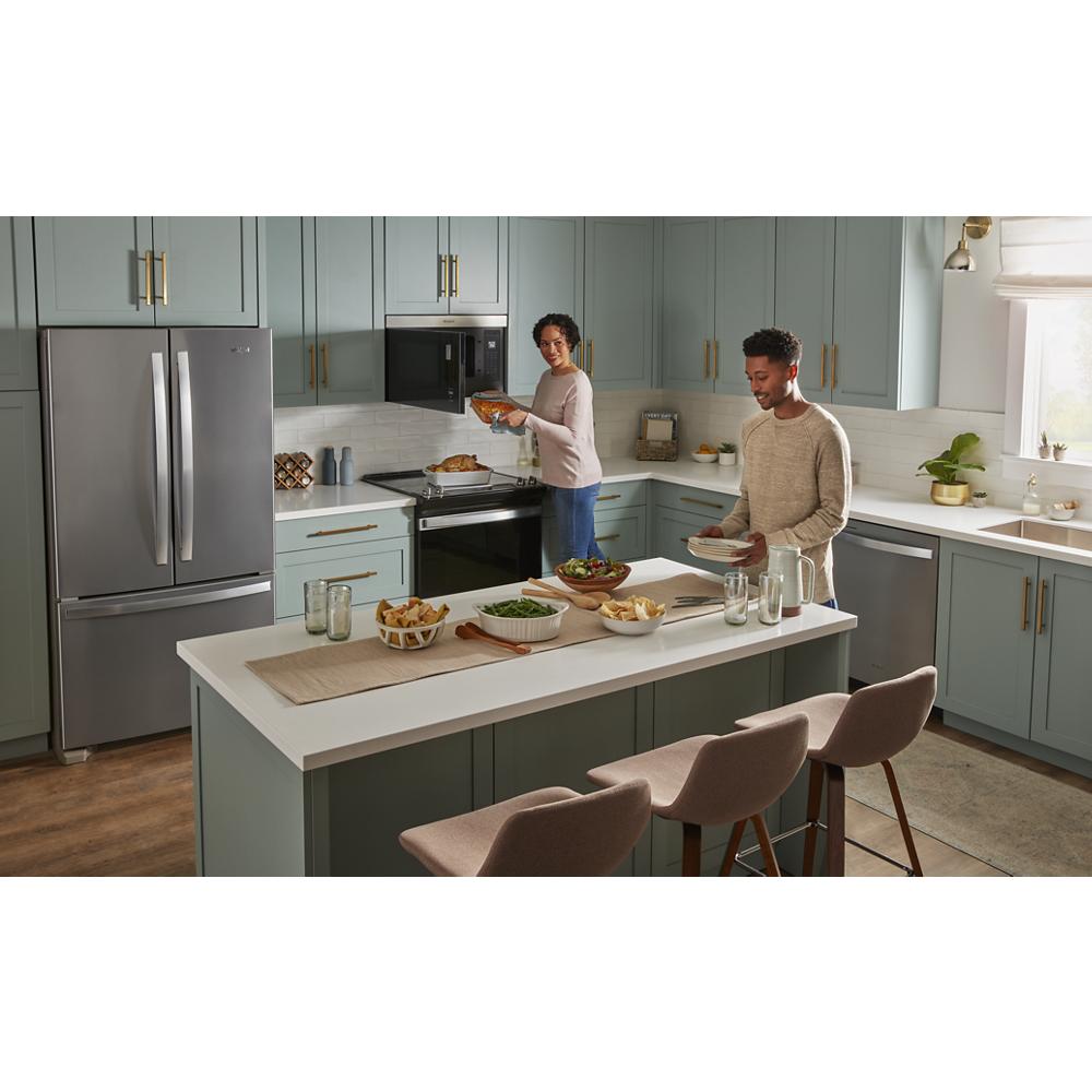 Modern kitchen with built-in microwave and stainless steel appliances, featuring blue-gray cabinetry and white countertops
