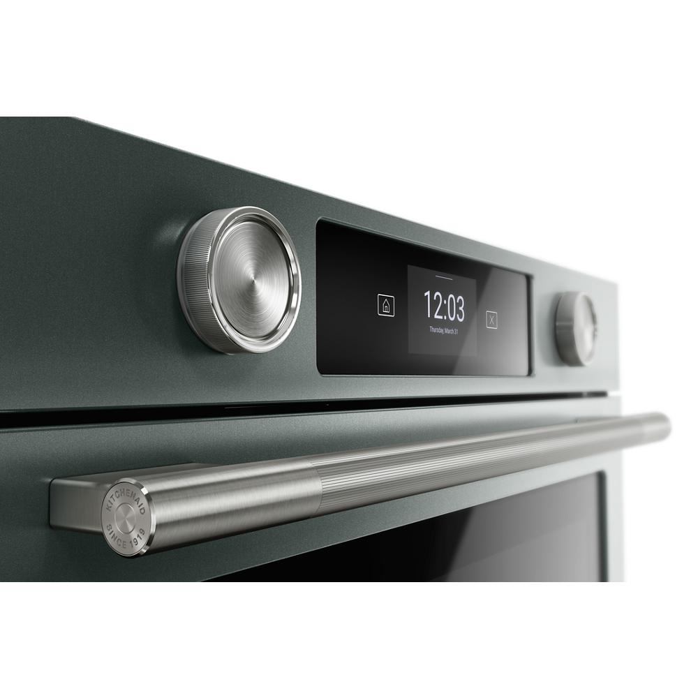 Close-up of smart electric wall oven with stainless steel knobs and handle in modern kitchen appliances collection