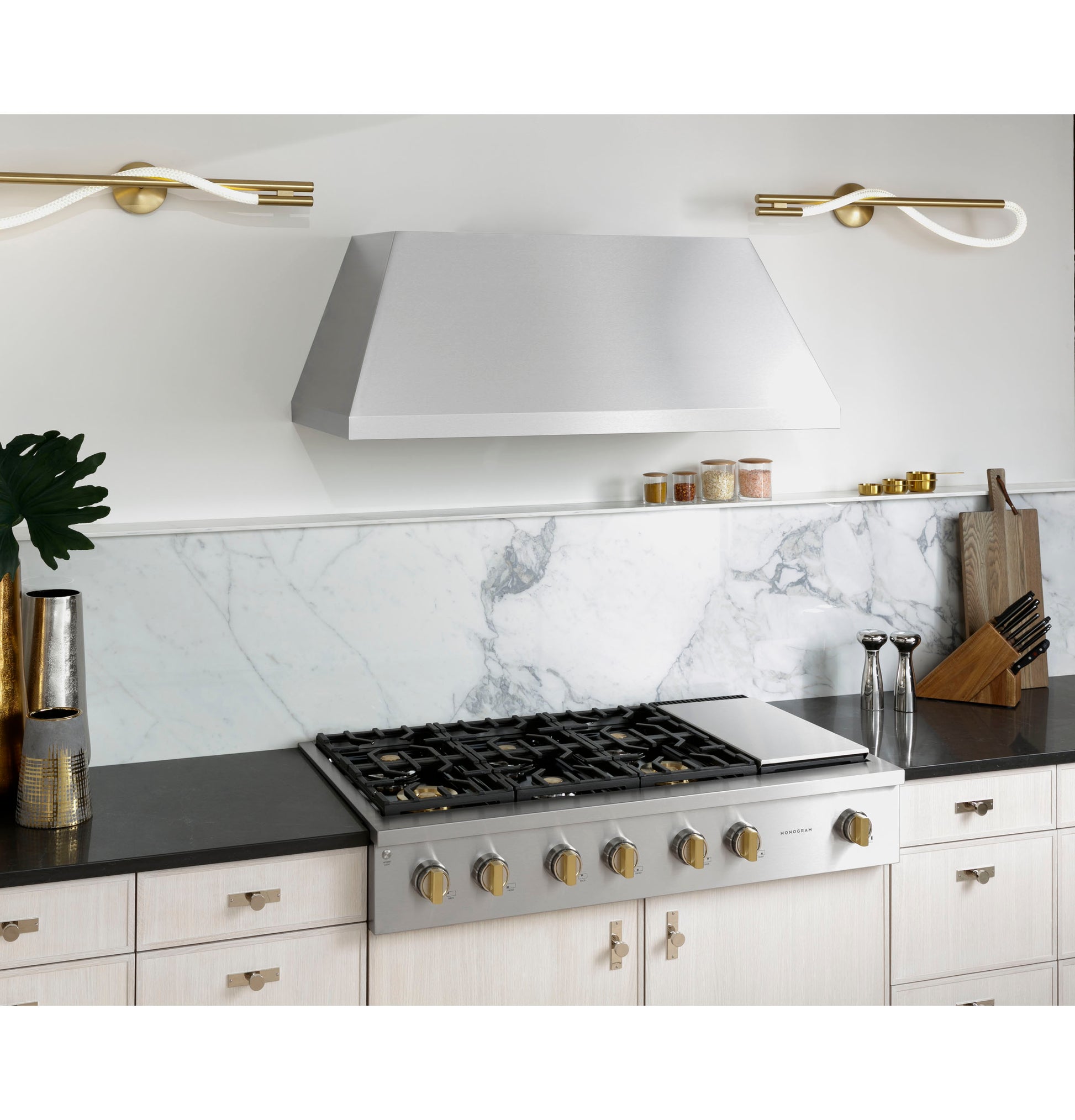 Stainless steel professional gas rangetop with six burners and griddle set in modern kitchen with marble backsplash