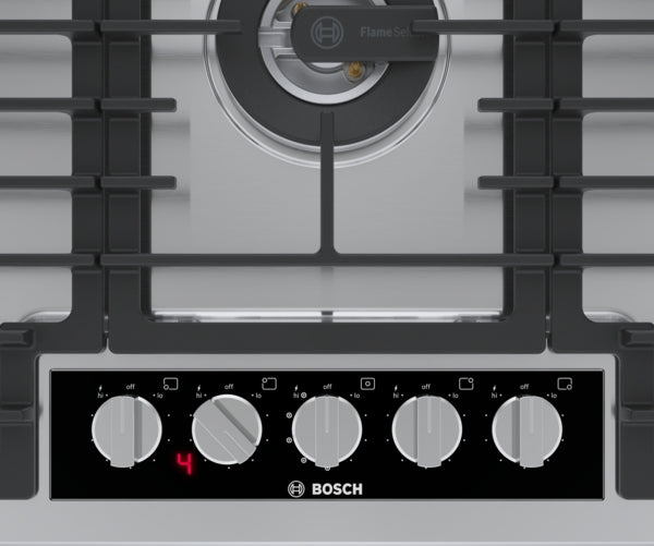 Close-up of stainless steel gas cooktop control panel with five knobs and digital display from Bosch Appliances collection