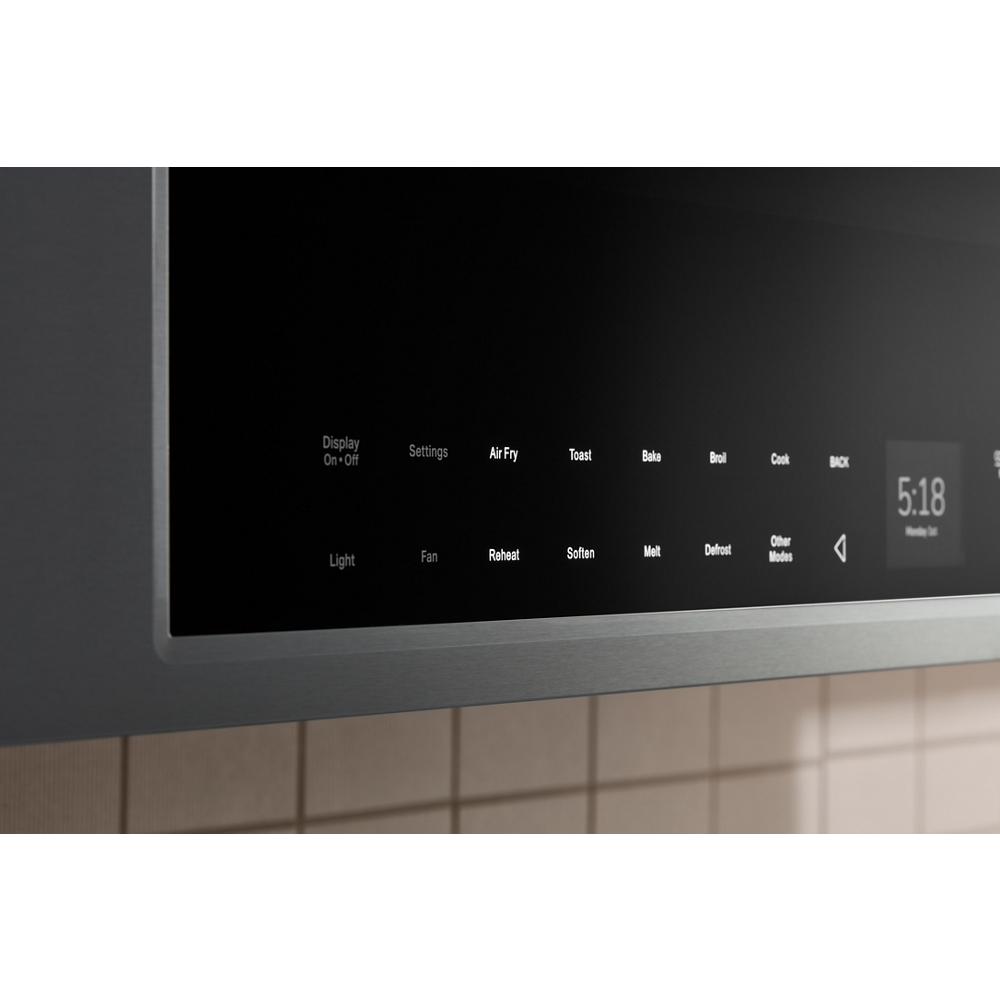 Close-up of touch control panel on stainless steel multifunction over-the-range oven showing cooking mode options and time display