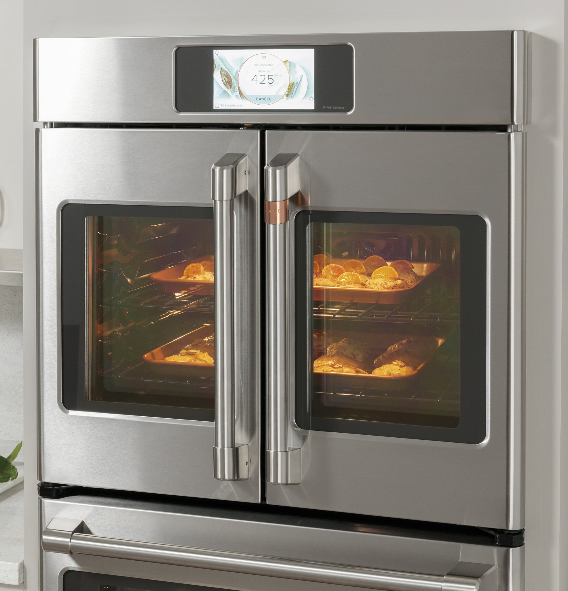 Stainless steel built-in double French-door wall oven with digital touchscreen and baked goods inside racks