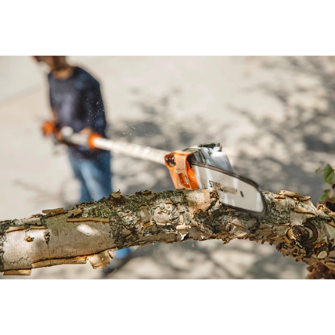 Extended pole pruner cutting a thick tree branch during outdoor home improvement and landscaping work