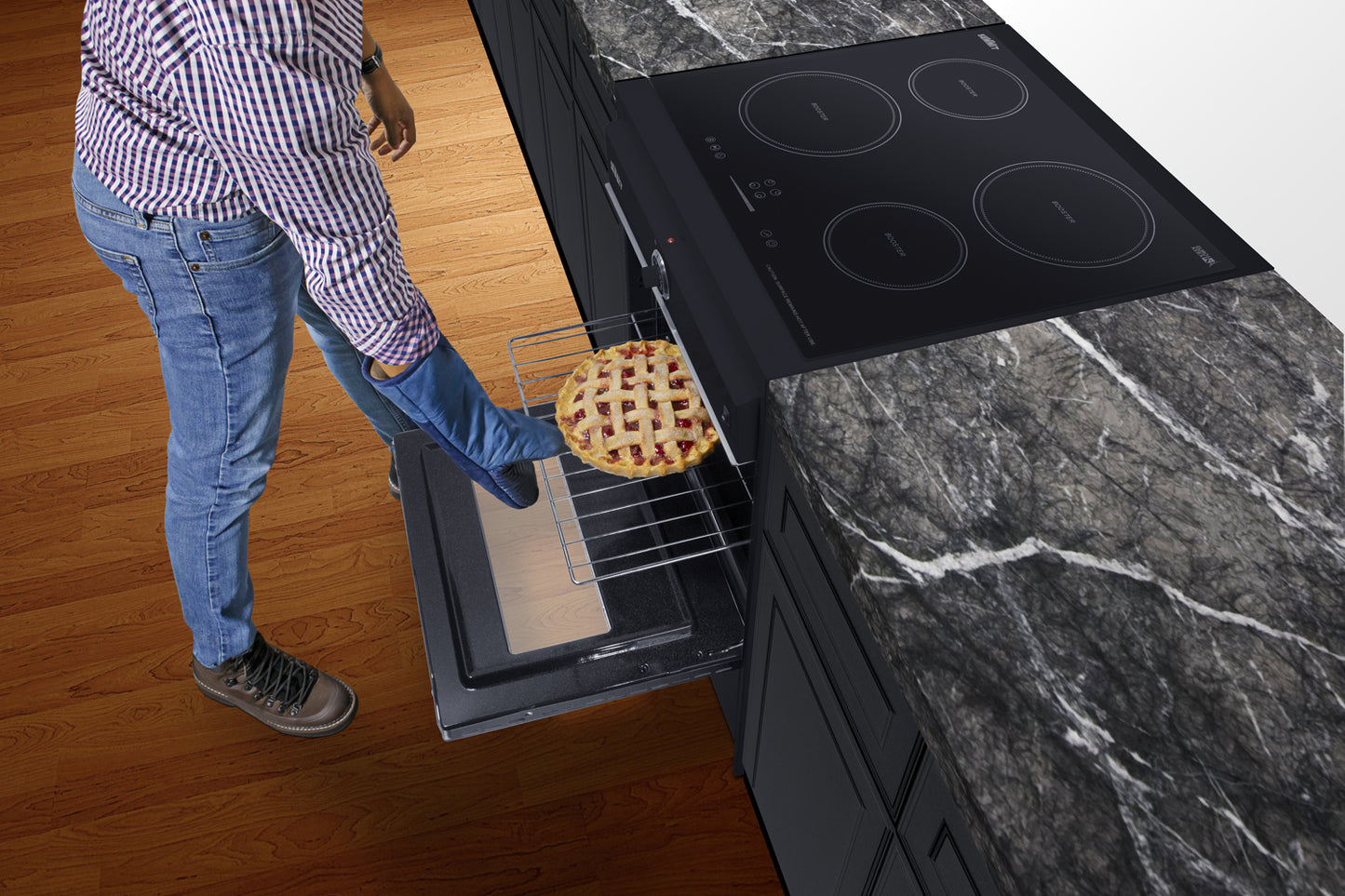 Person using foot pedal to open oven door of a modern kitchen with induction cooktop and marble countertop
