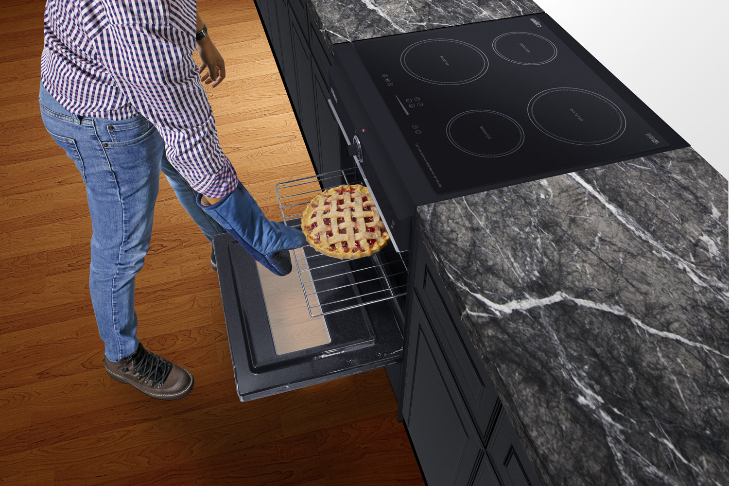 Person using foot pedal to open oven door of a modern kitchen with induction cooktop and marble countertop