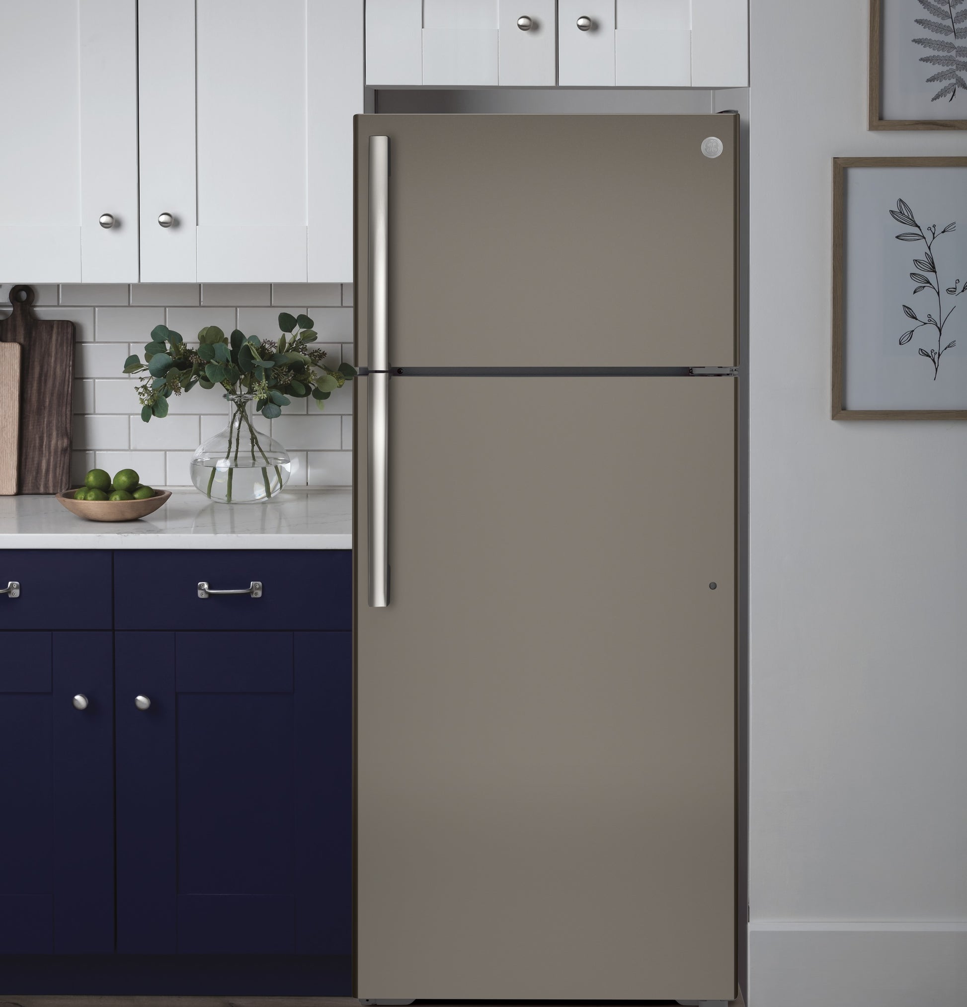 Brushed stainless steel top-freezer refrigerator in a modern kitchen with white and navy cabinets, refrigerators collection
