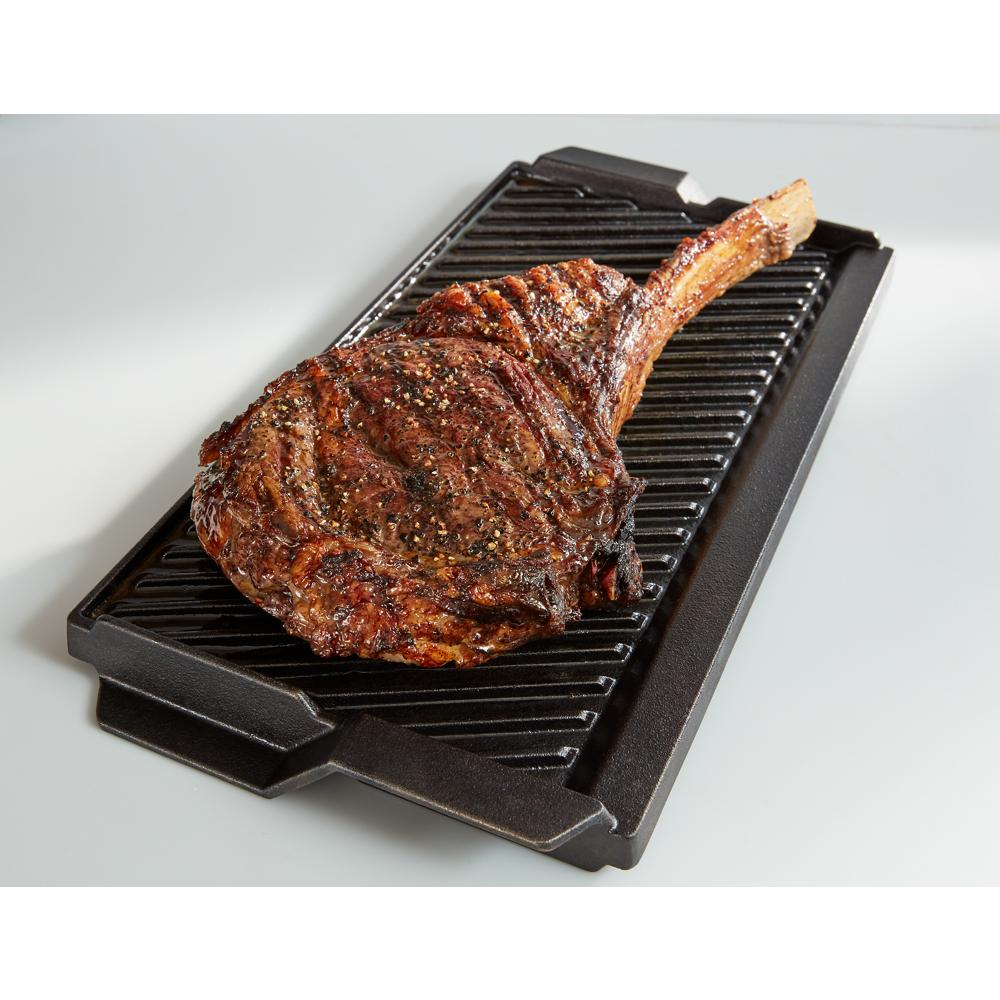 Grilled seasoned steak on a black cast iron grill pan in ranges and kitchen appliances collection
