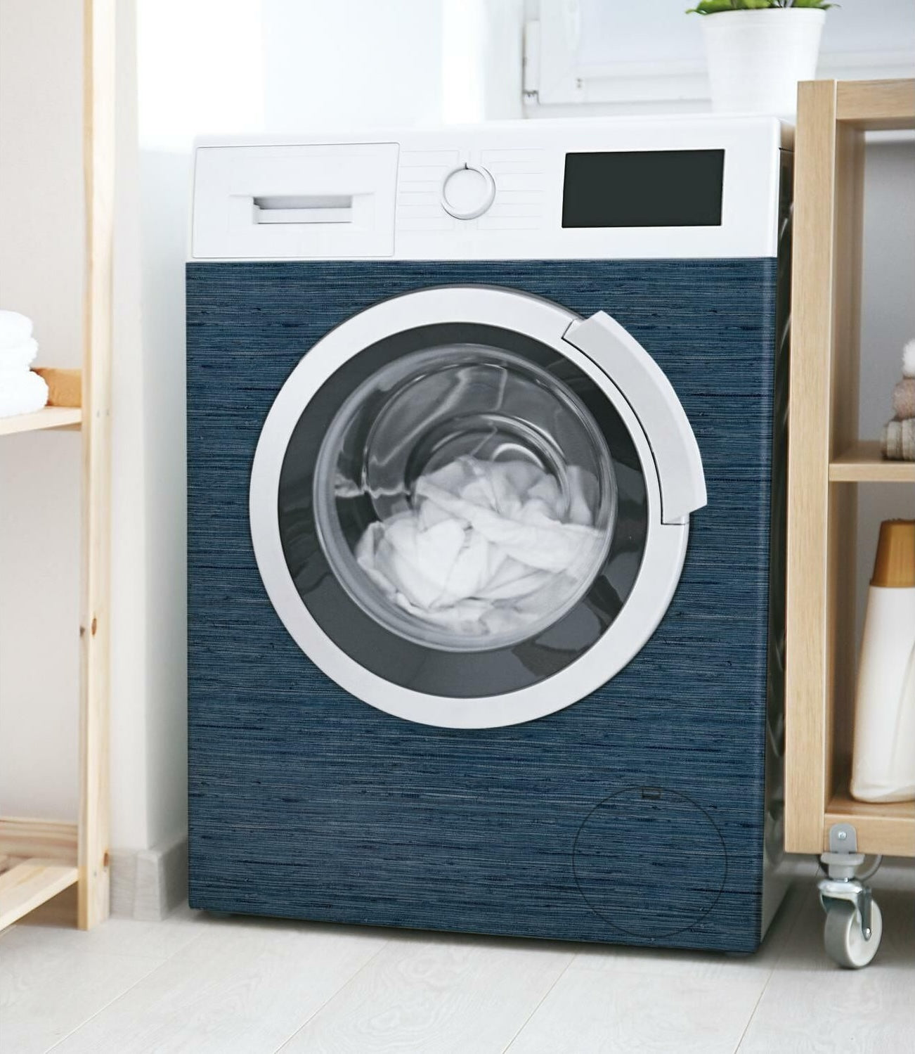 Front-loading washing machine wrapped in dark blue grasscloth textured vinyl peel and stick wallpaper in laundry room decor