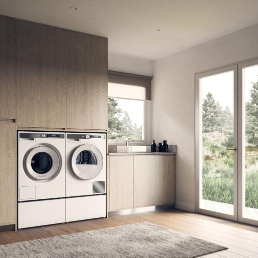 Laundry area featuring white front-load washer and dryer with pull-out storage drawers in a modern home setting
