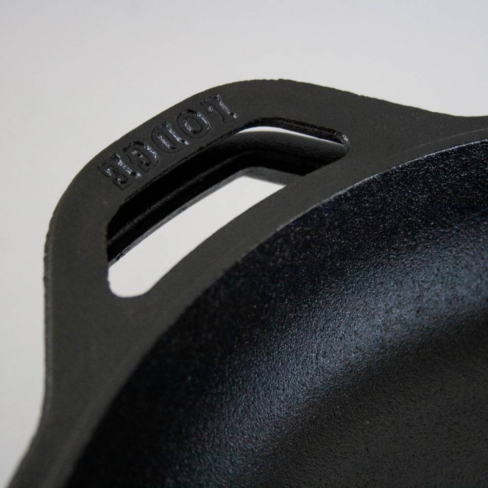 Close-up of black cast iron skillet handle with embossed Lodge brand in kitchenware and Lodge cast iron collections