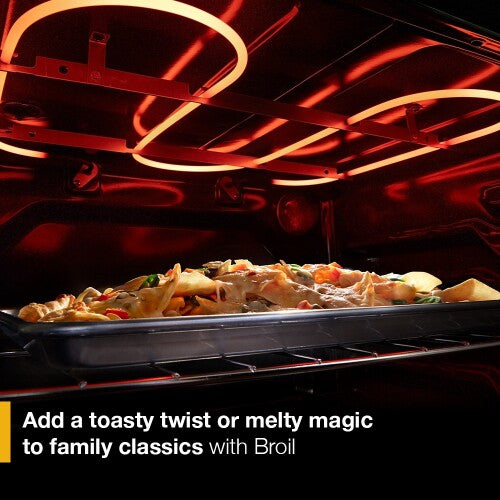 Interior view of gas range oven broiling a dish with glowing heating elements in kitchen appliances collection