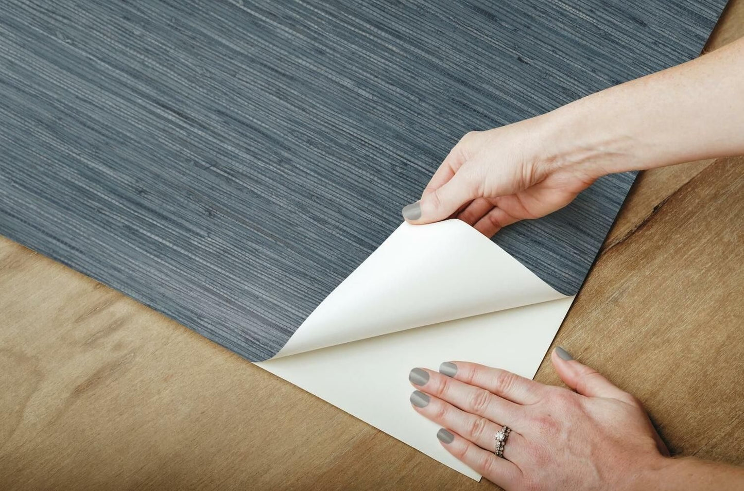 Peeling blue grasscloth textured vinyl wallpaper from wooden surface for easy home decor update under $100 collection