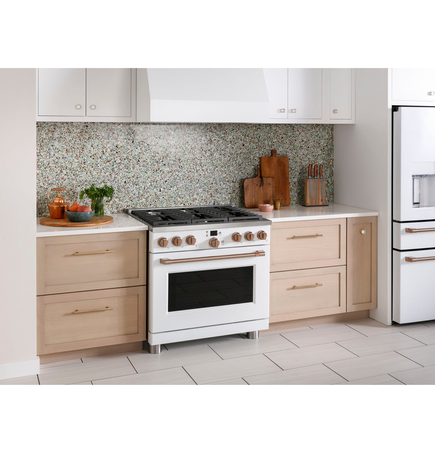 Smart all-gas range with six burners in modern kitchen, surrounded by light wood cabinetry and speckled backsplash