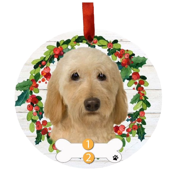 Round Christmas ornament featuring a cream Labradoodle with a festive holly and berry wreath and red ribbon hanger