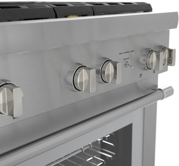 Close-up of stainless steel dual fuel range control panel with metallic knobs and oven door handle in kitchen appliances setting