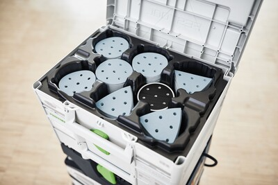 Open Festool branded tool storage box with organized blue abrasive sanding pads inside for woodworking tools and workshop organization.
