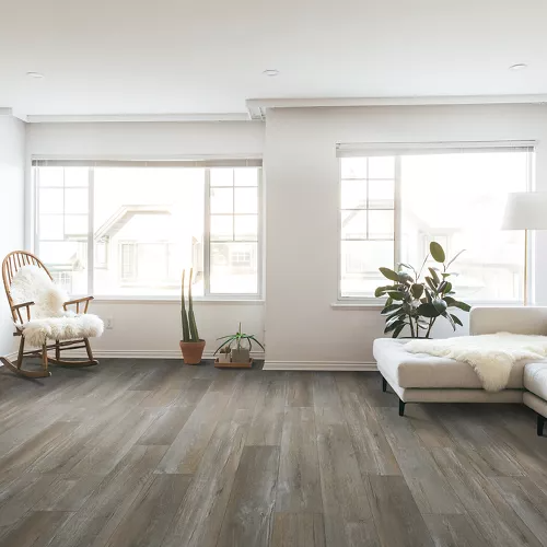 Bright living room with gray waterproof vinyl flooring, modern furniture, and natural light from large windows