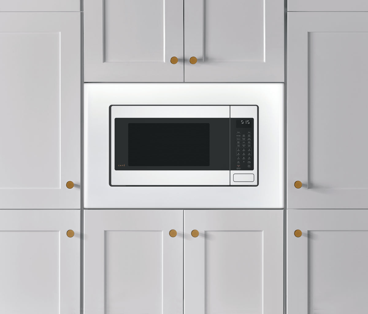 White built-in trim kit for 27-inch microwave set within modern gray kitchen cabinets in appliances and kitchenware collection