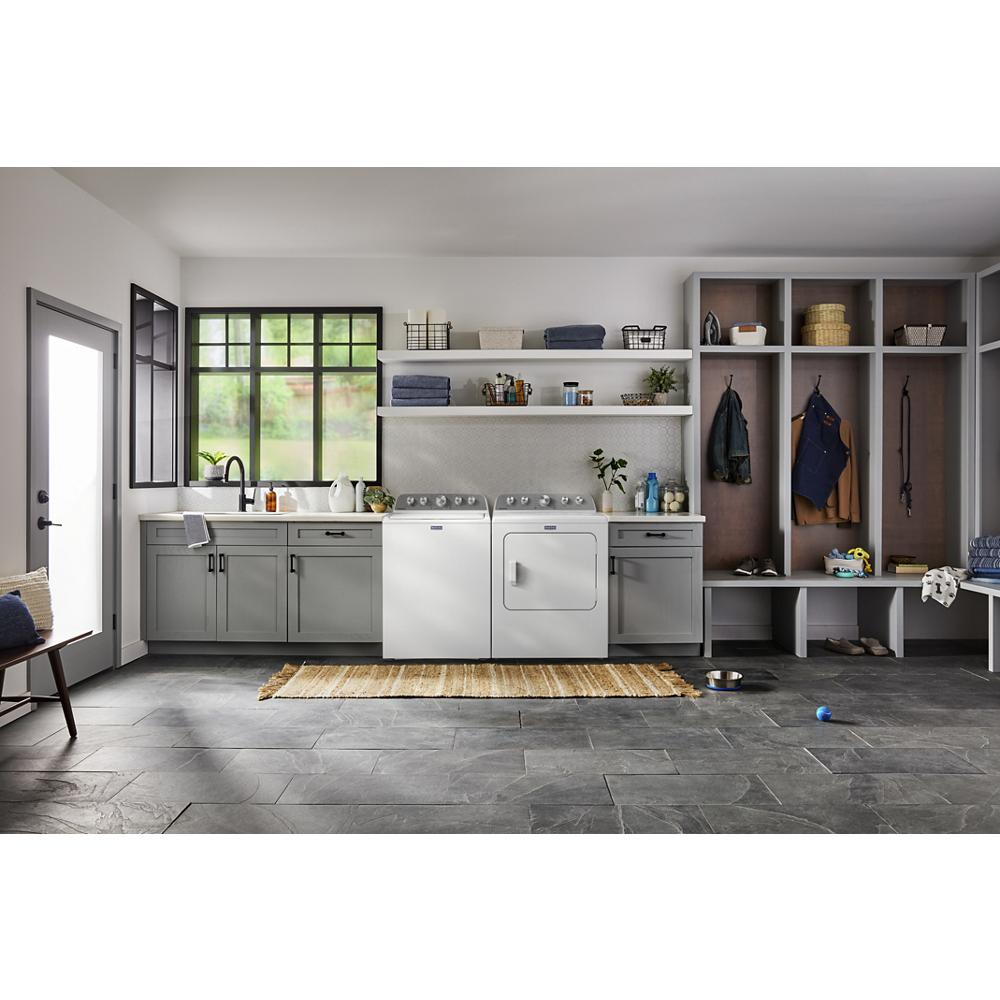 Laundry area with white top load washer and dryer surrounded by gray cabinets and organized open wooden storage lockers.