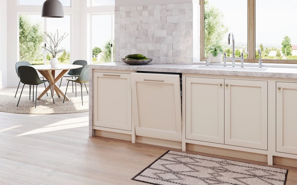 Seamlessly integrated 24-inch custom panel ready dishwasher in elegant light beige cabinetry within modern kitchen and dining area