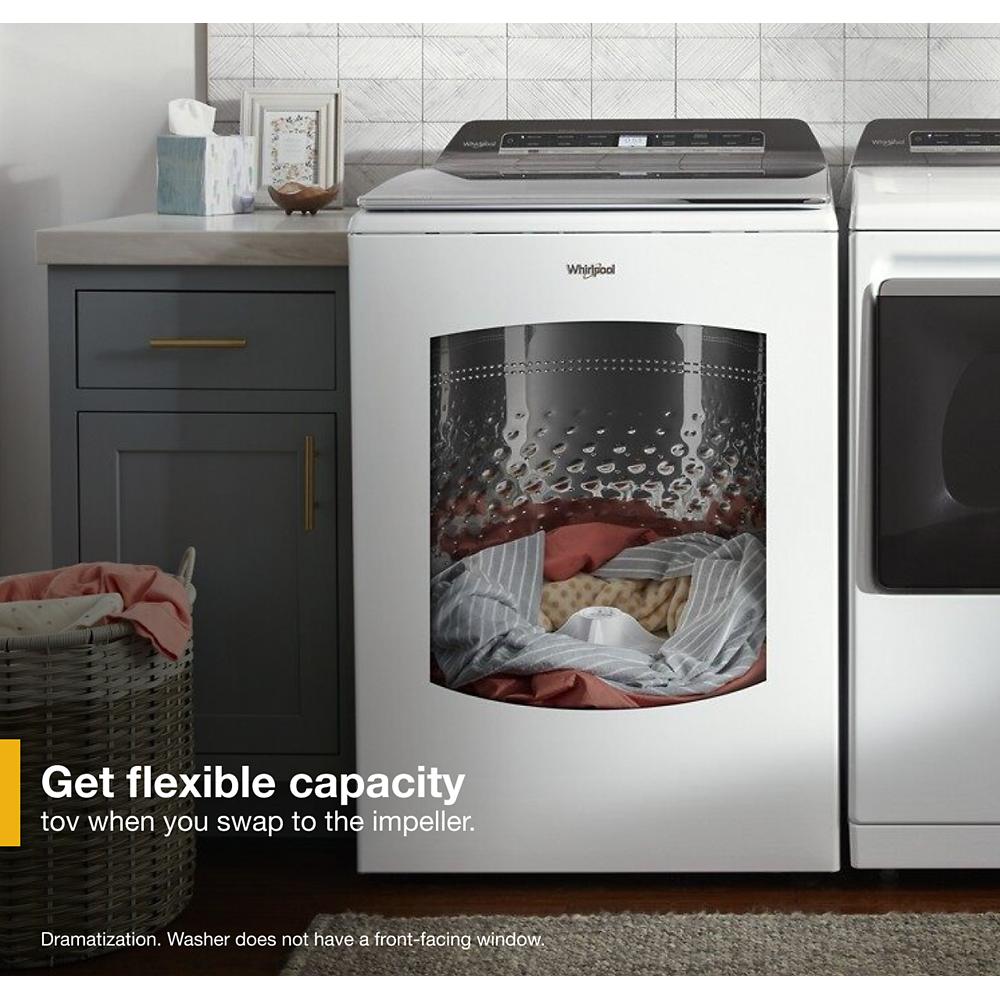 White Whirlpool top load washer with digital controls shown in laundry room with gray cabinetry and basket of laundry