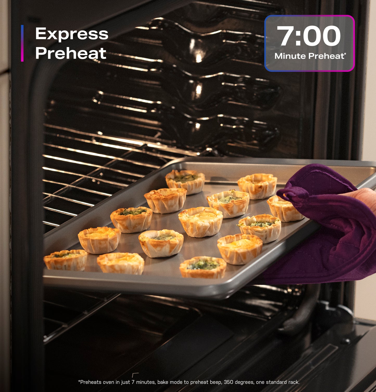 Hand placing EasyWash™ oven tray with mini quiches into gas convection range preheated in modern kitchen setting