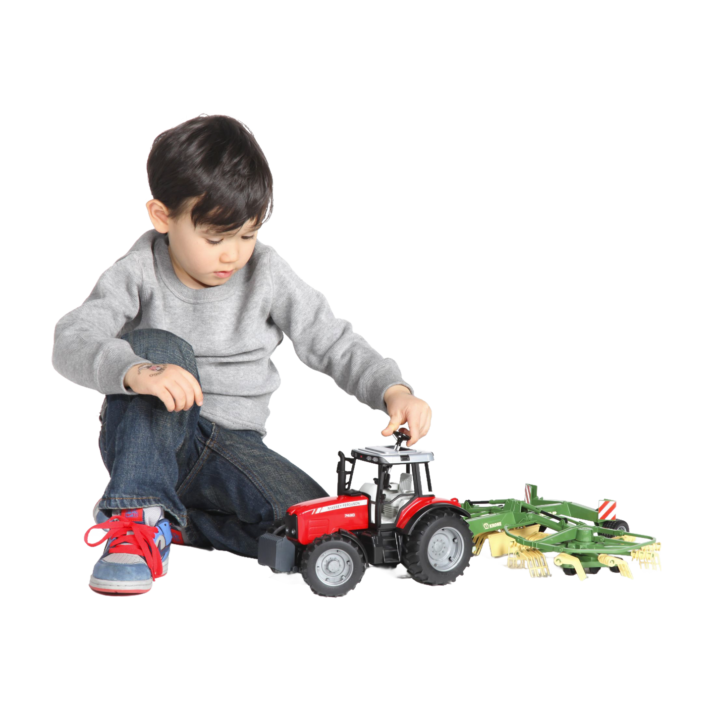 Child playing with red tractor toy attached to green farming implement in toys and vehicles collection under $100