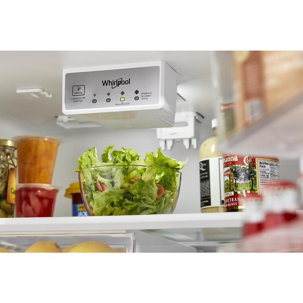 Interior view of a Whirlpool top freezer refrigerator showing fresh produce and control panel for kitchen appliances collections