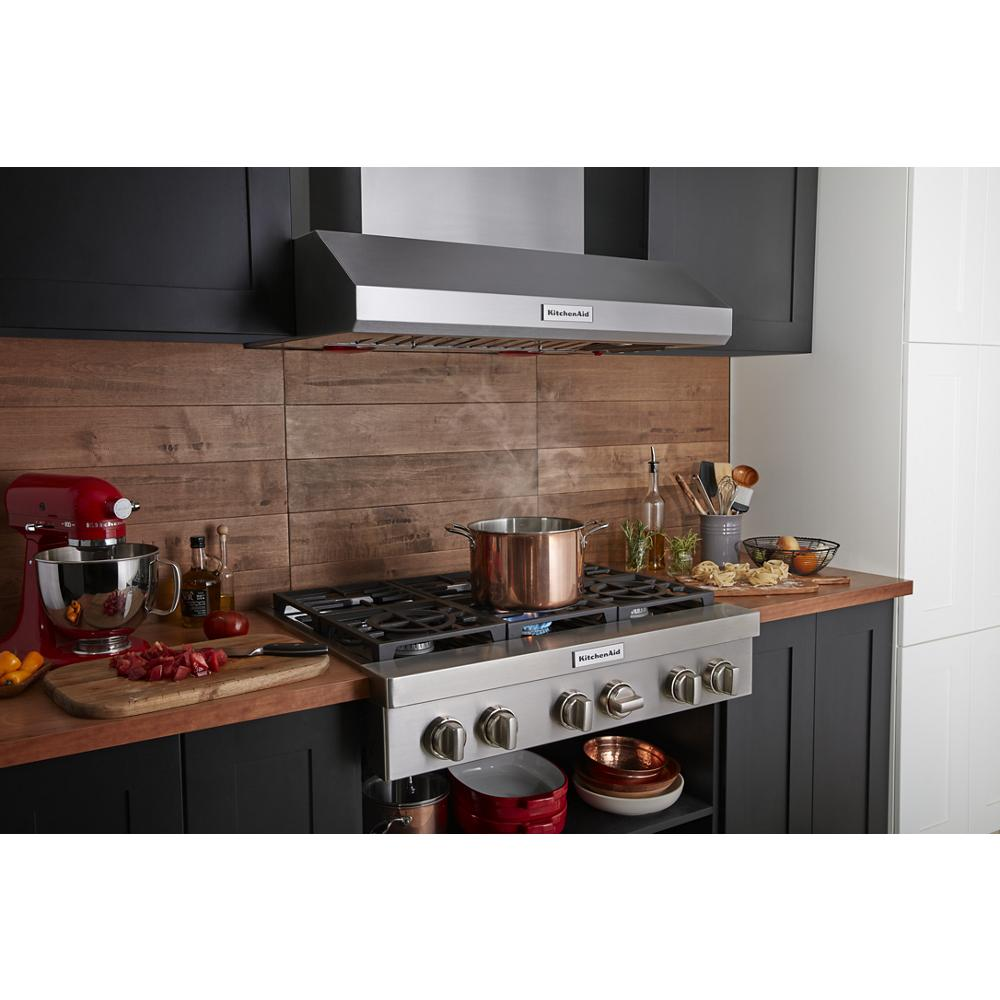 Stainless steel 6-burner commercial-style gas rangetop with pot boiling and wood backsplash in kitchenware collection