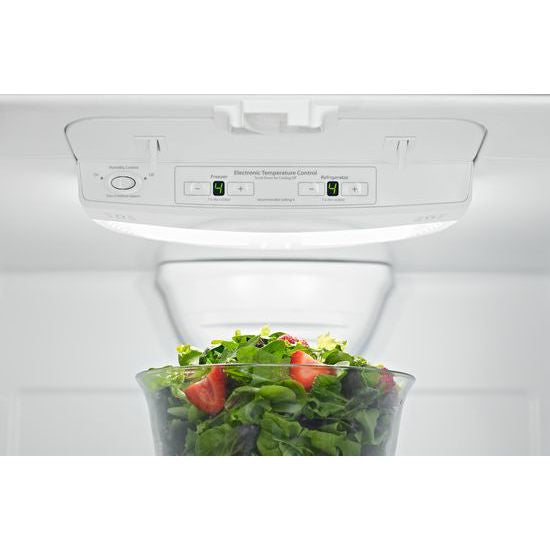 Electronic temperature control panel with bright LED display inside refrigerator storing fresh salad greens