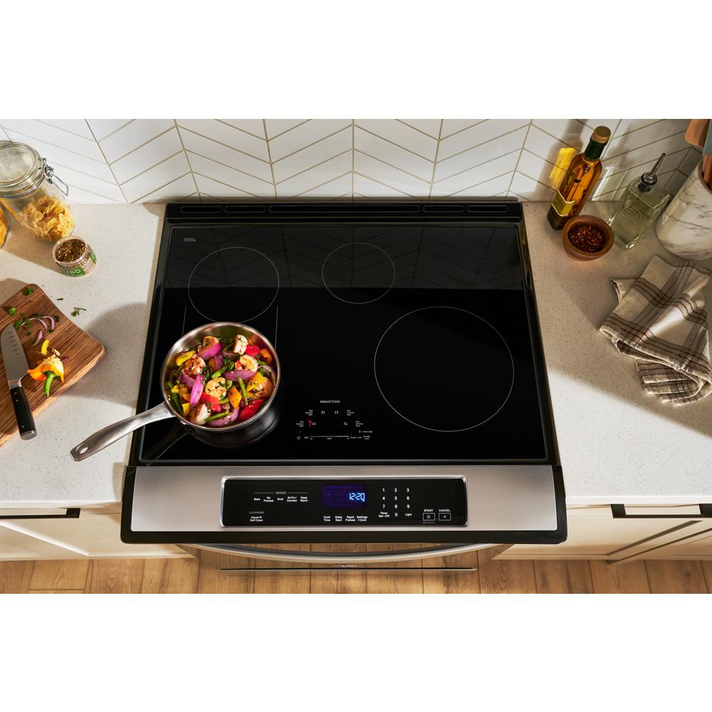 black and stainless steel 30-inch induction range with digital touch controls and vegetable stir fry in kitchen appliances collection