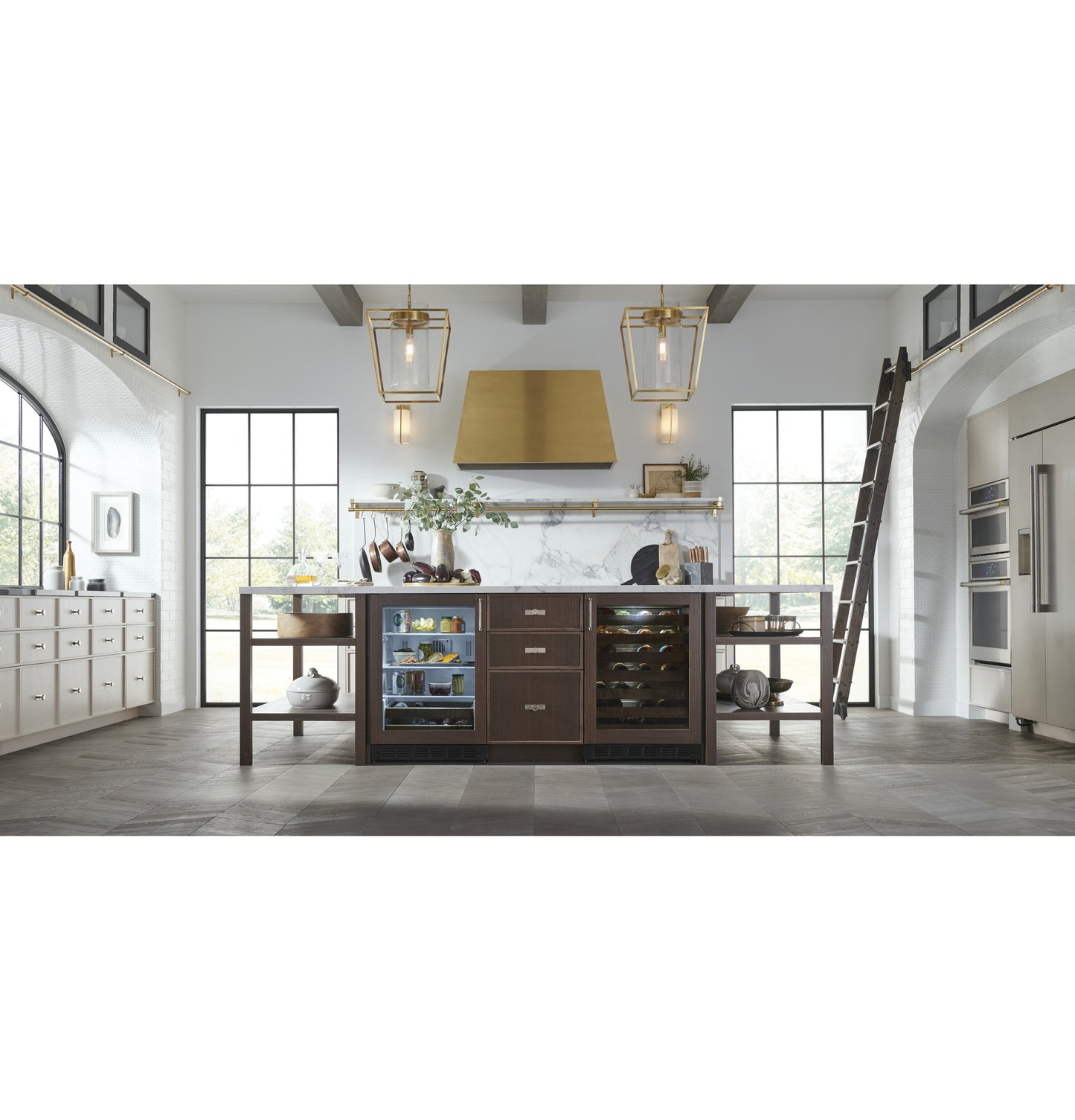 Modern kitchen featuring a brass range hood over island with built-in wine and beverage coolers in appliances collection