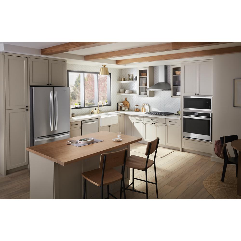 Modern kitchen with stainless steel refrigerator, built-in microwave, ovens, and light wood cabinetry in Kitchen & Kitchenware collection