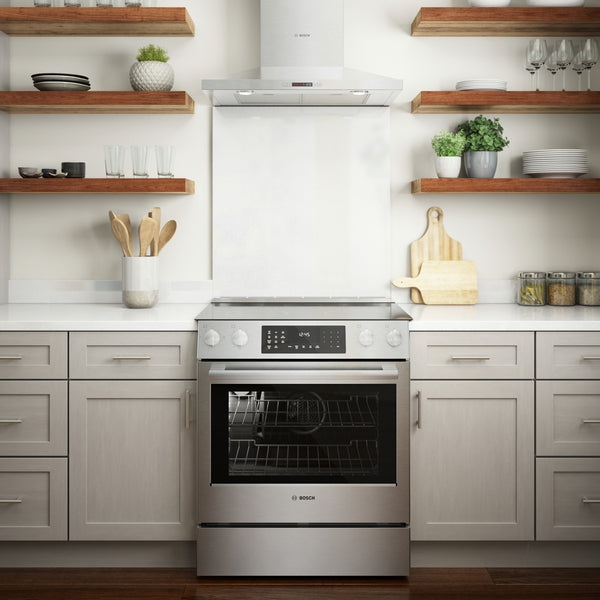Electric slide-in stainless steel range with digital display and heavy-duty knobs in modern kitchen setting