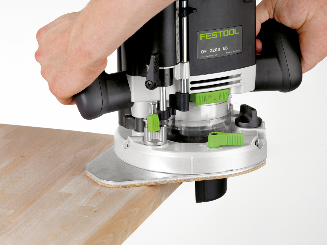 Hands operating Festool router with dust collection on light wood surface for woodworking tools collection