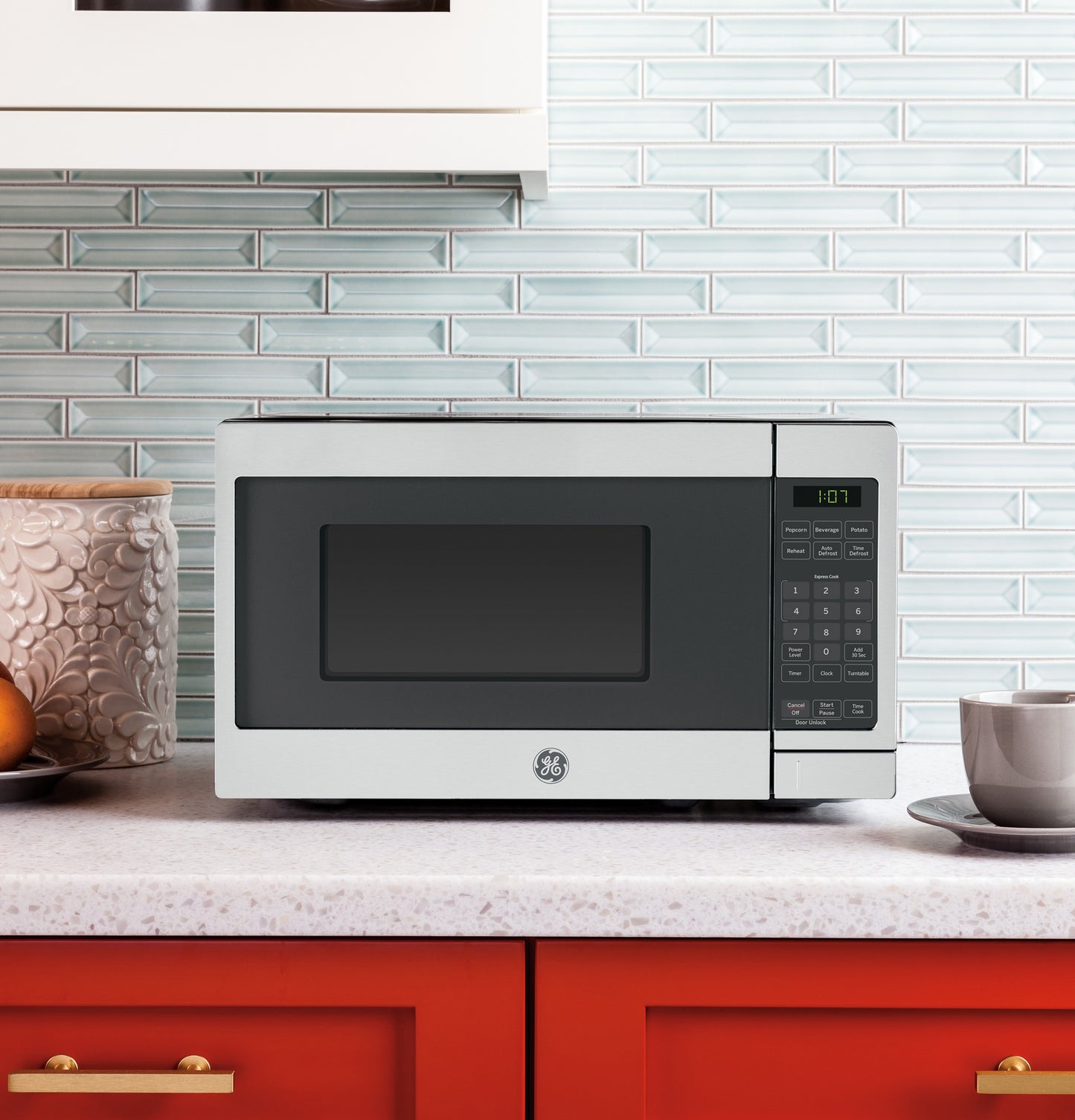 Compact countertop microwave with digital keypad and timer on white countertop in modern kitchen setting