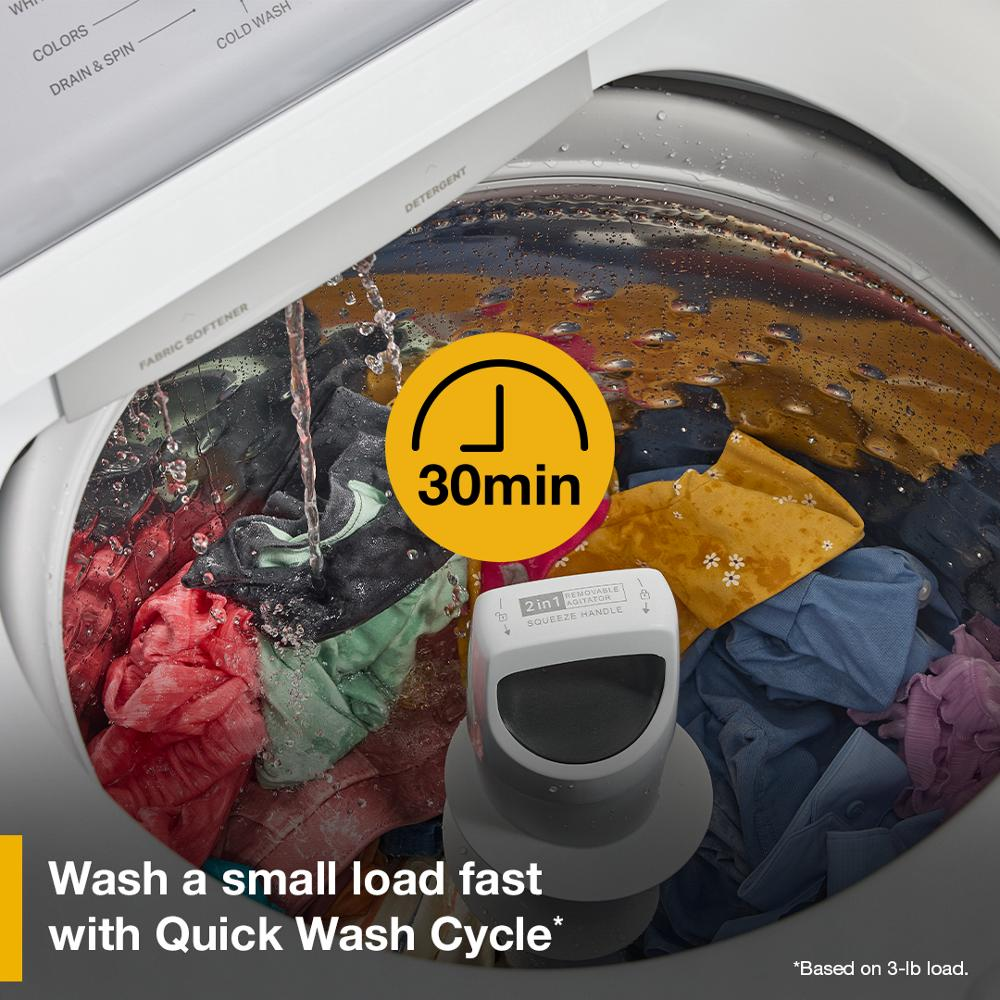 Open white top load washer filling with water over colorful clothes and central removable agitator in home appliance setting