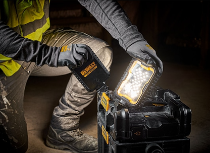Worker wearing gloves adjusting DEWALT Toughsystem 2.0 work light with dual LEDs on jobsite for home improvement tools