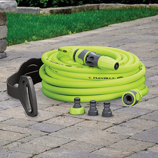 Coiled bright green heavy duty garden hose with quick connect fittings, nozzle, and hose hanger on stone patio