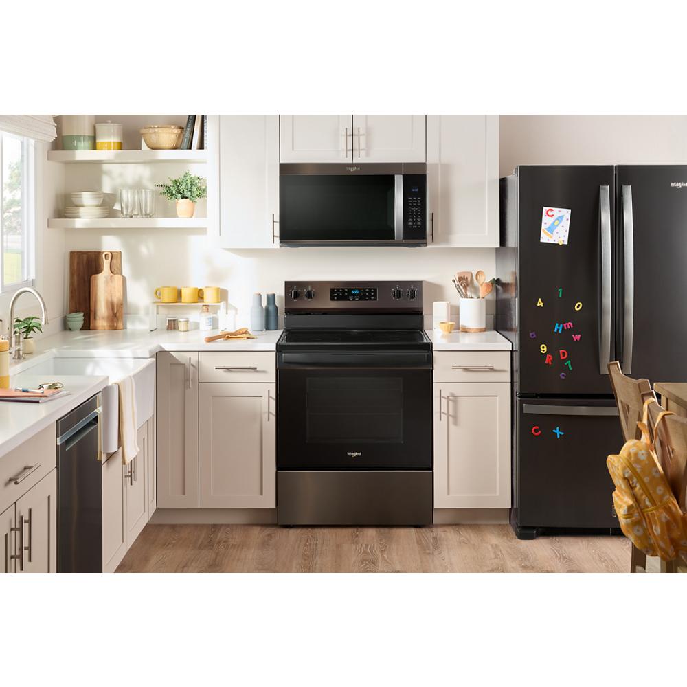 Modern kitchen with black Whirlpool appliances including over the range microwave, electric stove, and refrigerator