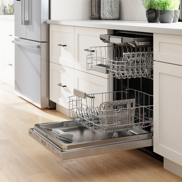 Open stainless steel dishwasher with empty racks integrated into bright modern kitchen cabinetry and hardwood floor