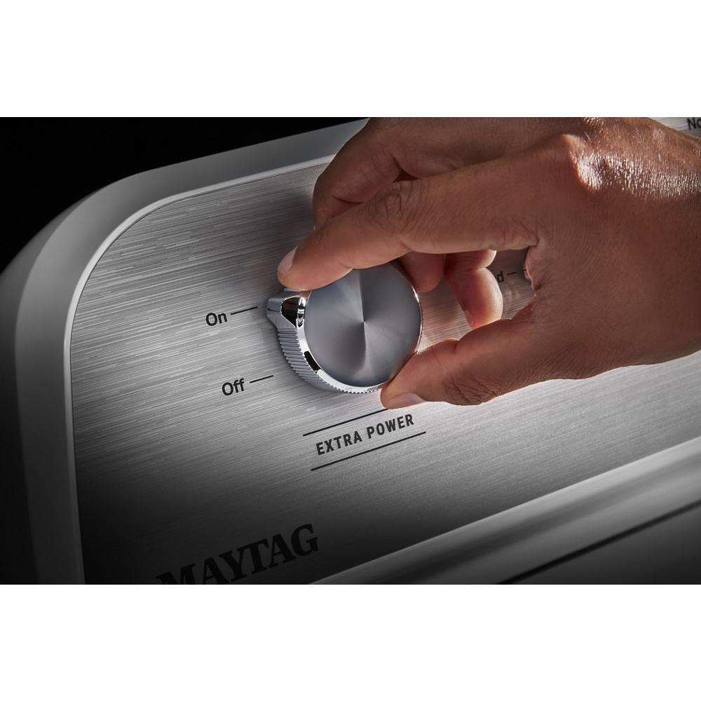 Close-up of hand adjusting silver knob on Maytag gas dryer control panel labeled Extra Power in appliances collection